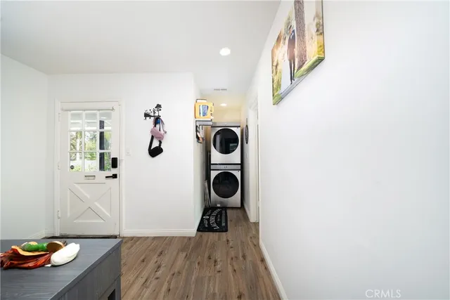 a view of a hallway to a livingroom with furniture wooden floor cabinet and windows