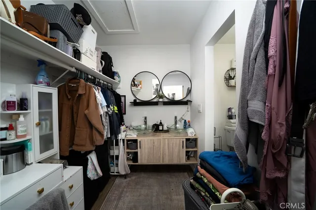 a view of walk in closet with clothes and shoes