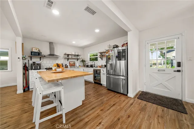 a kitchen with a refrigerator a sink and dishwasher with wooden floor