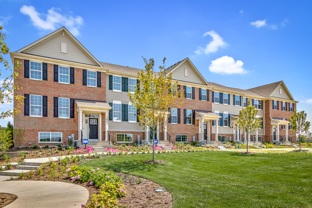a front view of a residential apartment building with a yard