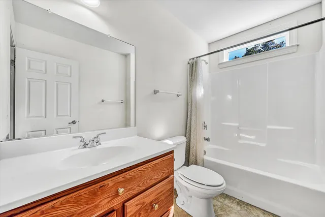 an empty room with a window and a ceiling fan