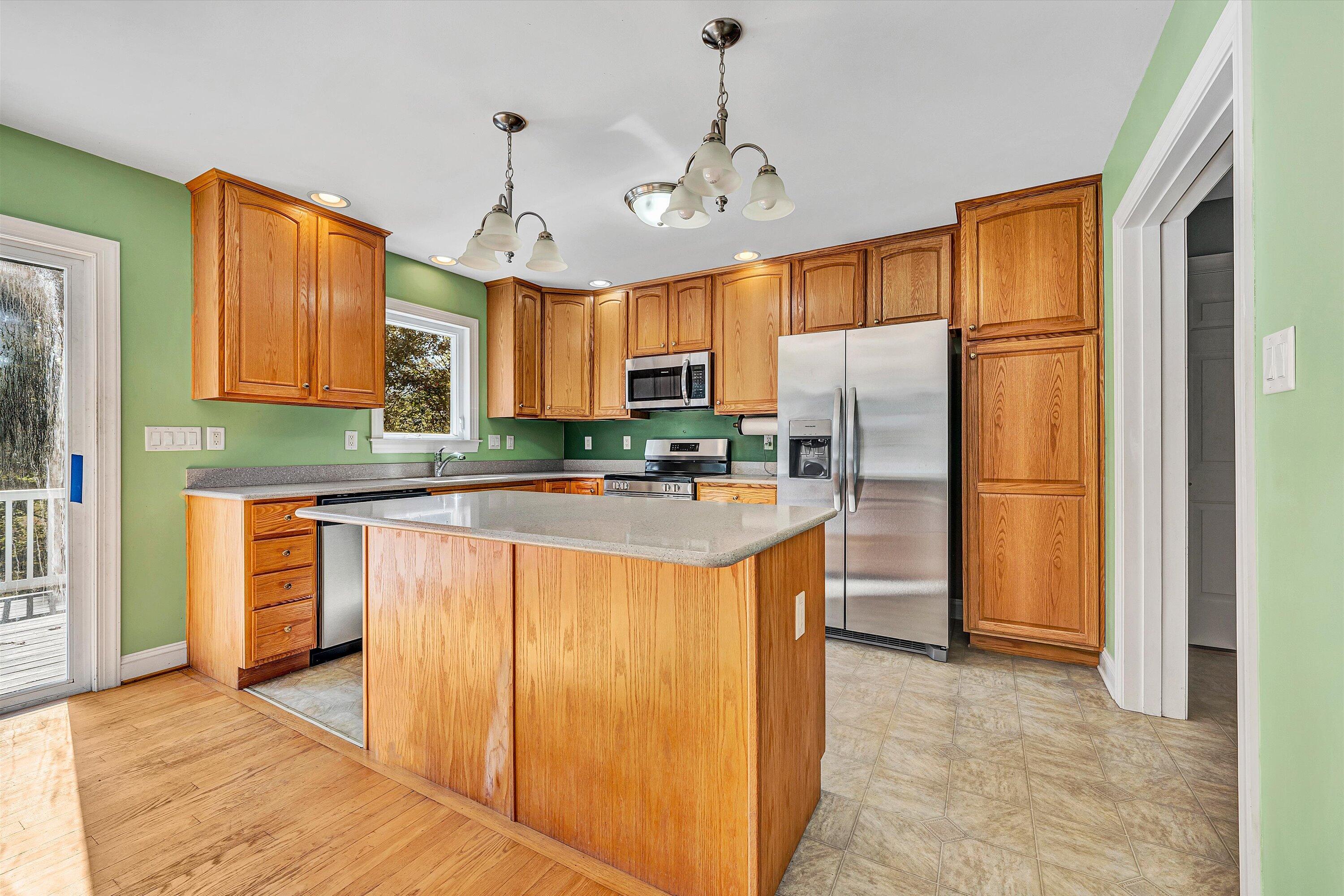 401 Piney Ridge Road Covington, VA 24426 - Photo 10 of 83 a kitchen with stainless steel appliances granite countertop a refrigerator a sink dishwasher a stove with wooden cabinets and floor