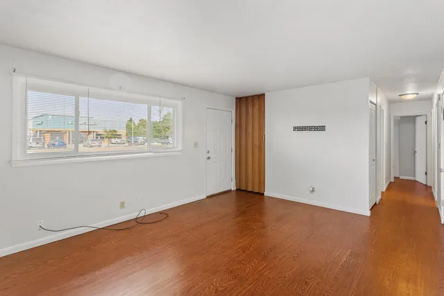 a kitchen with stainless steel appliances a refrigerator a sink dishwasher a oven with white cabinets and wooden floor