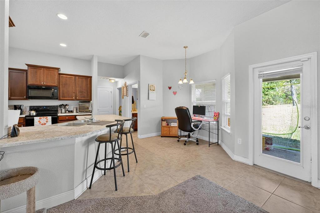 2005 Angel Fish Loop Leesburg, FL 34748 - Photo 18 of 54 a view of kitchen with stainless steel appliances granite countertop dining table chairs and a refrigerator