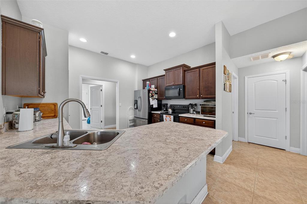 2005 Angel Fish Loop Leesburg, FL 34748 - Photo 19 of 54 a kitchen with kitchen island a sink stainless steel appliances and a counter top space