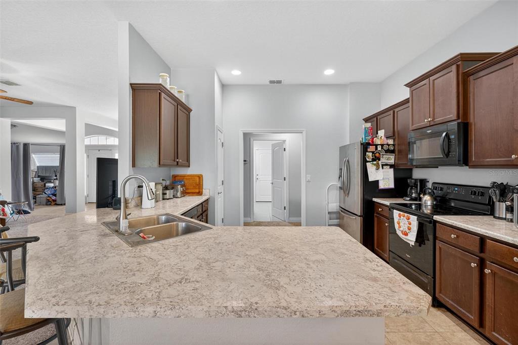 2005 Angel Fish Loop Leesburg, FL 34748 - Photo 21 of 54 a large kitchen with stainless steel appliances granite countertop a stove refrigerator and a sink