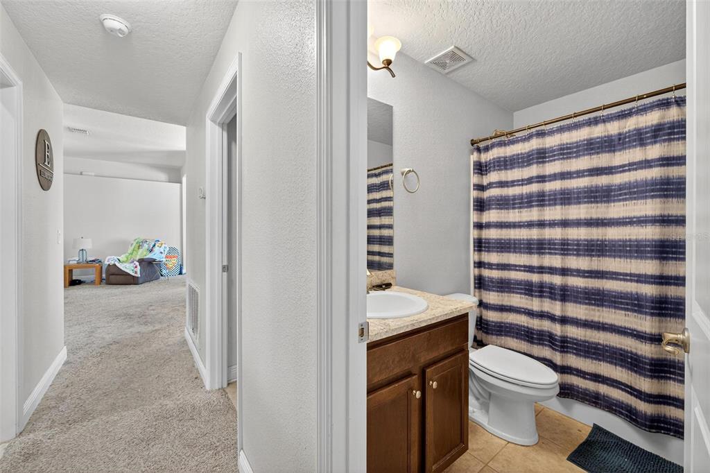 2005 Angel Fish Loop Leesburg, FL 34748 - Photo 37 of 54 a bathroom with a sink a toilet and shower curtain