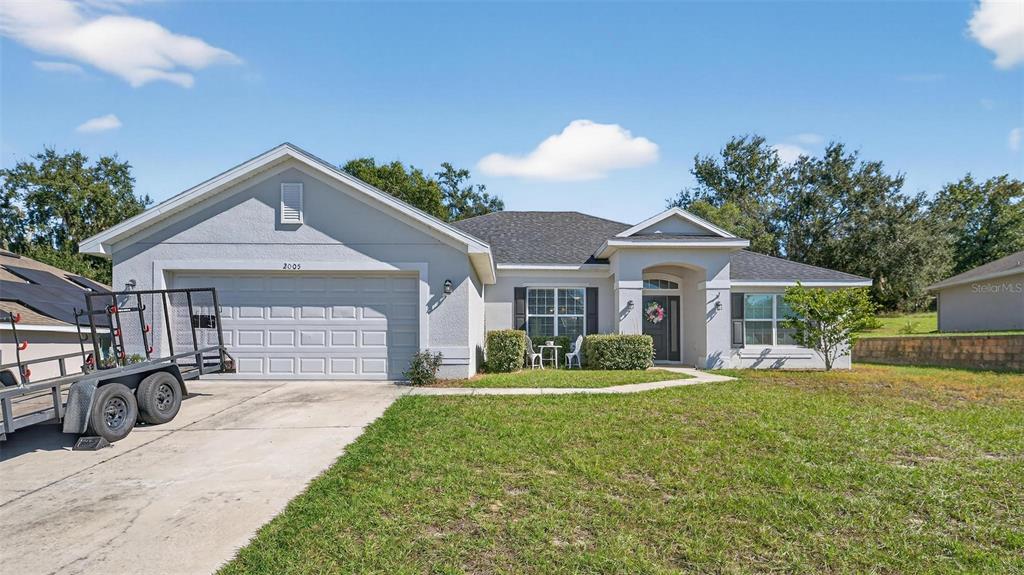 2005 Angel Fish Loop Leesburg, FL 34748 - Photo 4 of 54 a front view of a house with a yard and garage