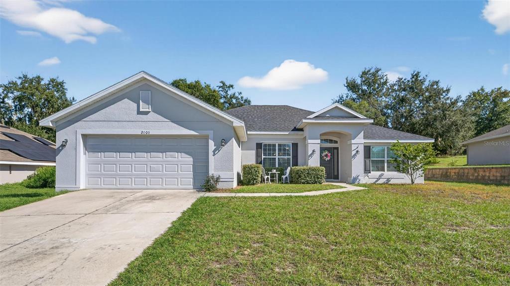 2005 Angel Fish Loop Leesburg, FL 34748 - Photo 5 of 54 a front view of a house with a yard and garage