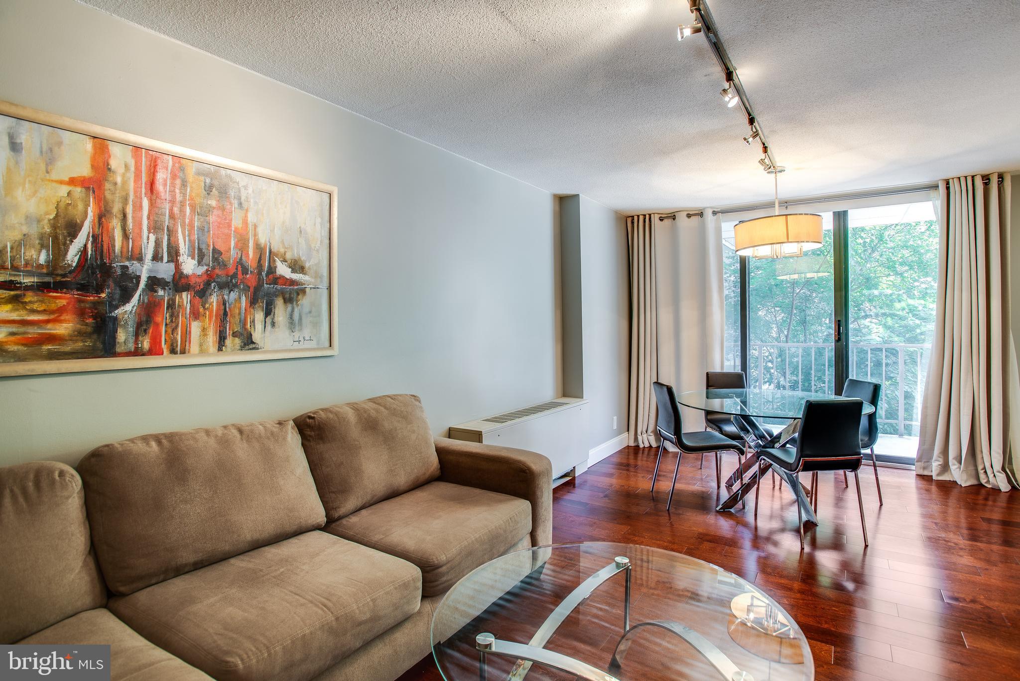 2201 L Street Northwest, Unit 500 Washington, DC 20037 - Photo 11 of 43 a living room with furniture and floor to ceiling windows