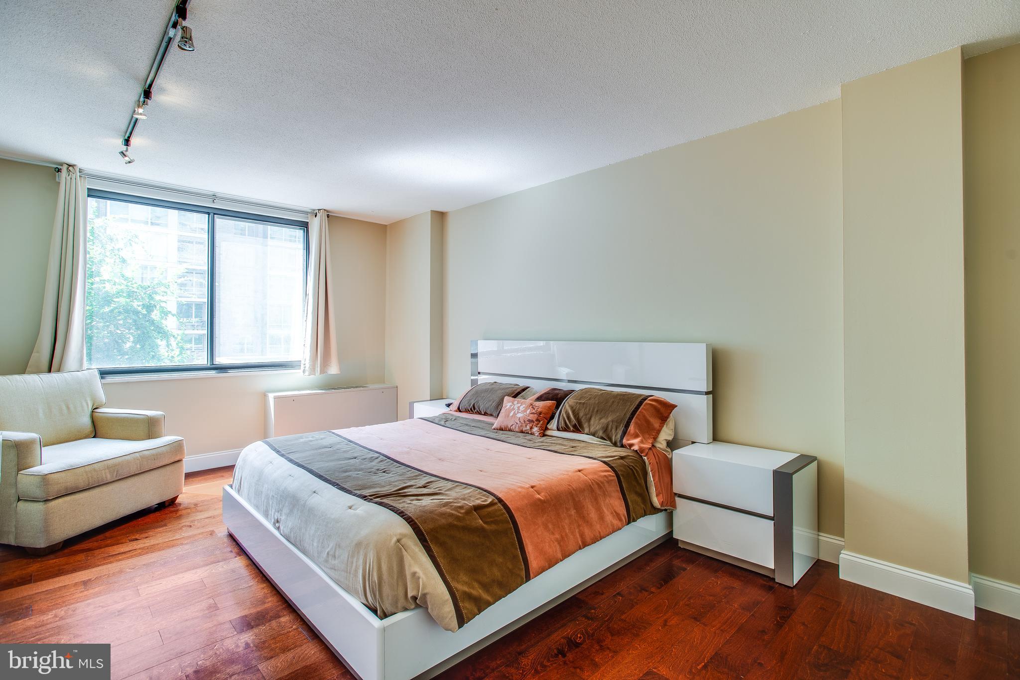 2201 L Street Northwest, Unit 500 Washington, DC 20037 - Photo 14 of 43 a bedroom with a bed and a couch