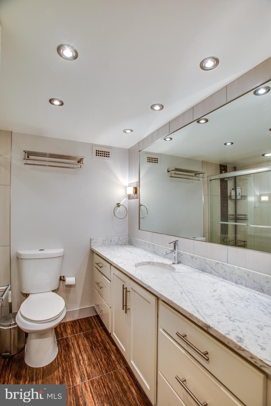 2201 L Street Northwest, Unit 500 Washington, DC 20037 - Photo 17 of 43 a bathroom with a granite countertop sink a toilet and a mirror