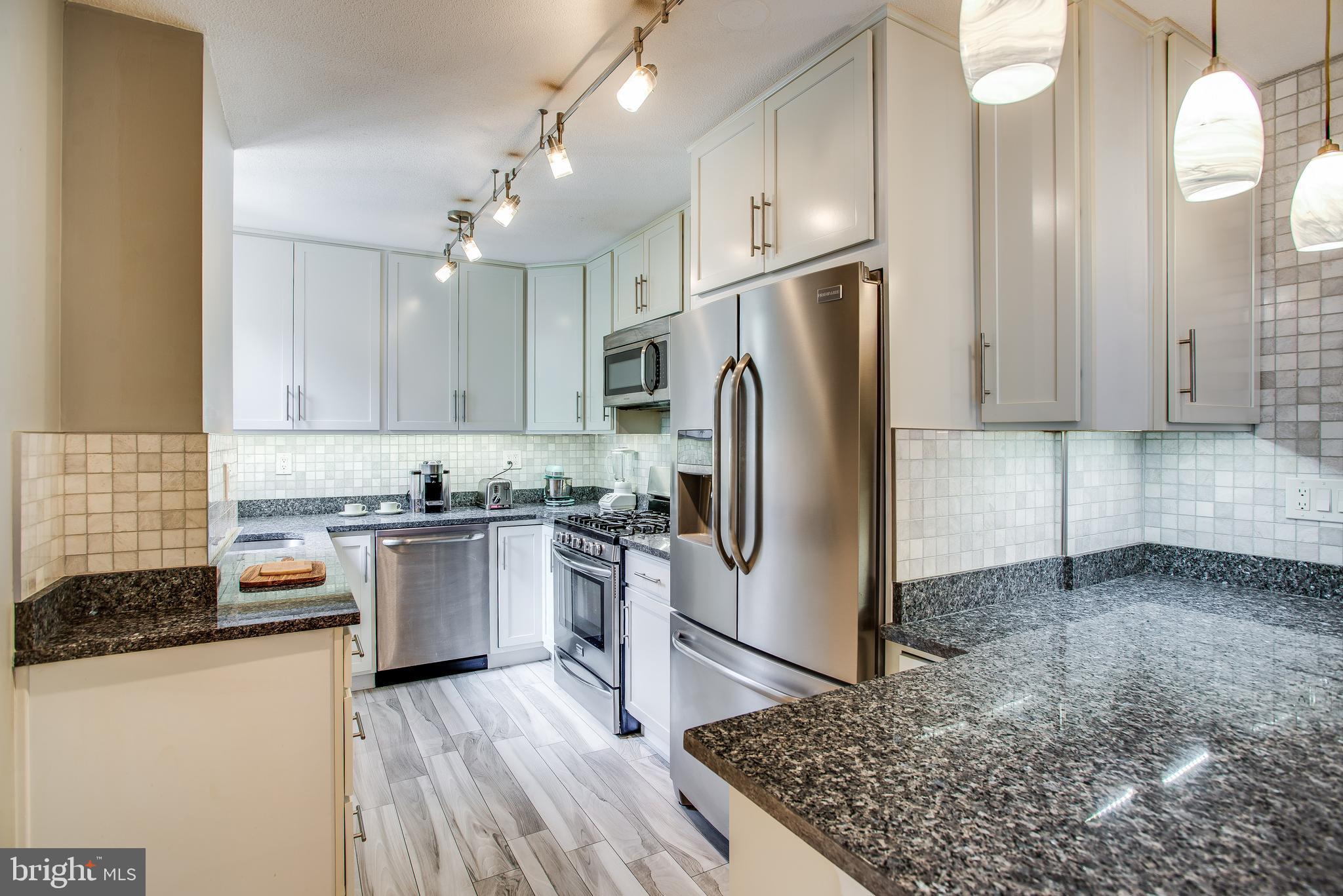 2201 L Street Northwest, Unit 500 Washington, DC 20037 - Photo 4 of 43 a kitchen with stainless steel appliances granite countertop a refrigerator sink and stove