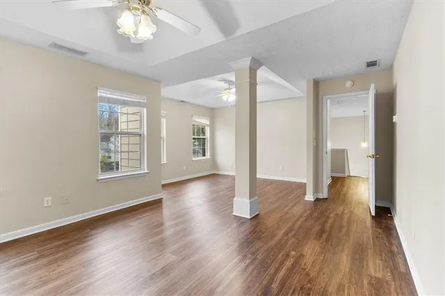 an empty room with wooden floor and windows