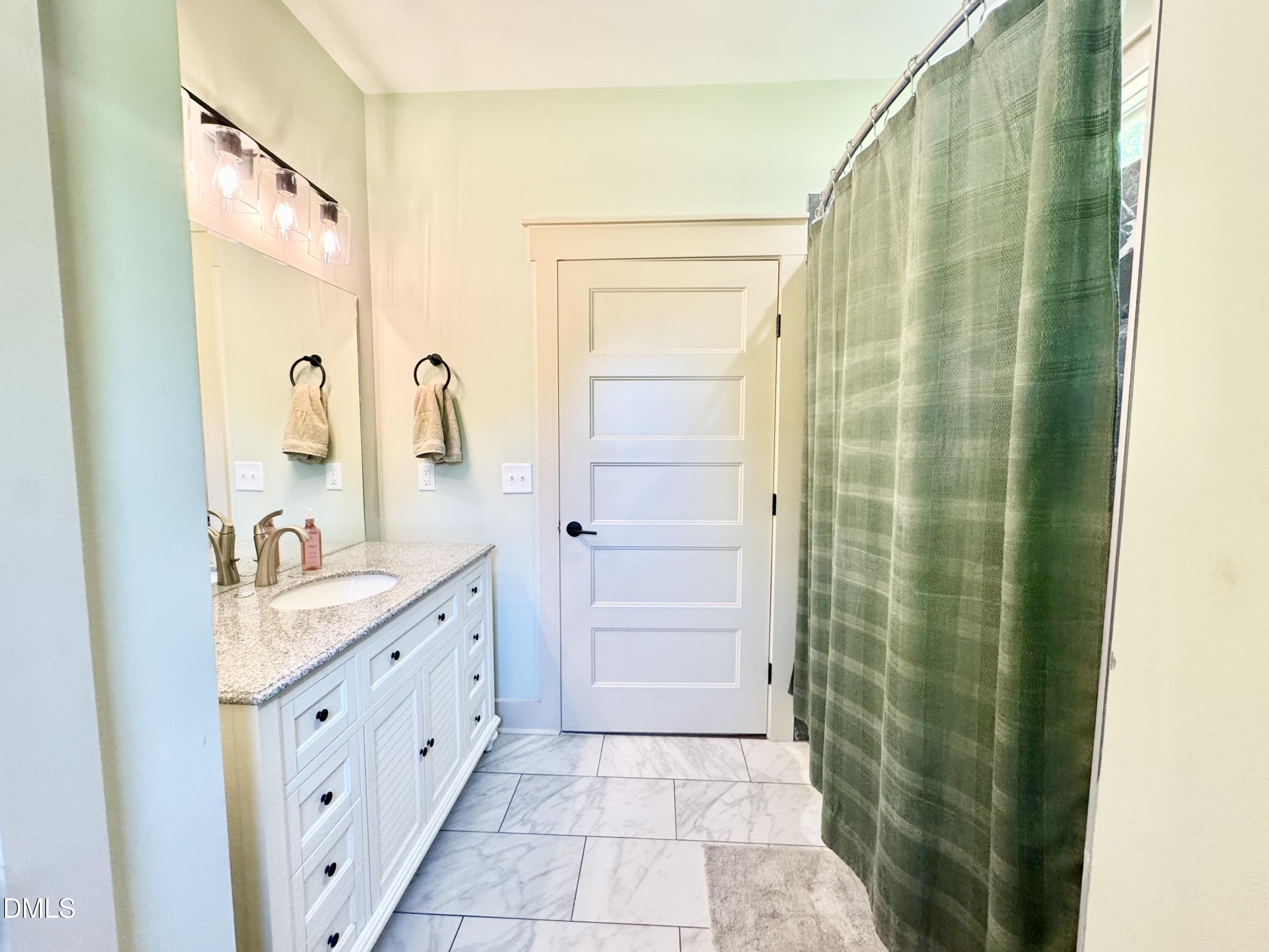 254 Fairway Drive Roxboro, NC 27574 - Photo 20 of 28 a bathroom with a granite countertop sink a mirror and a shower