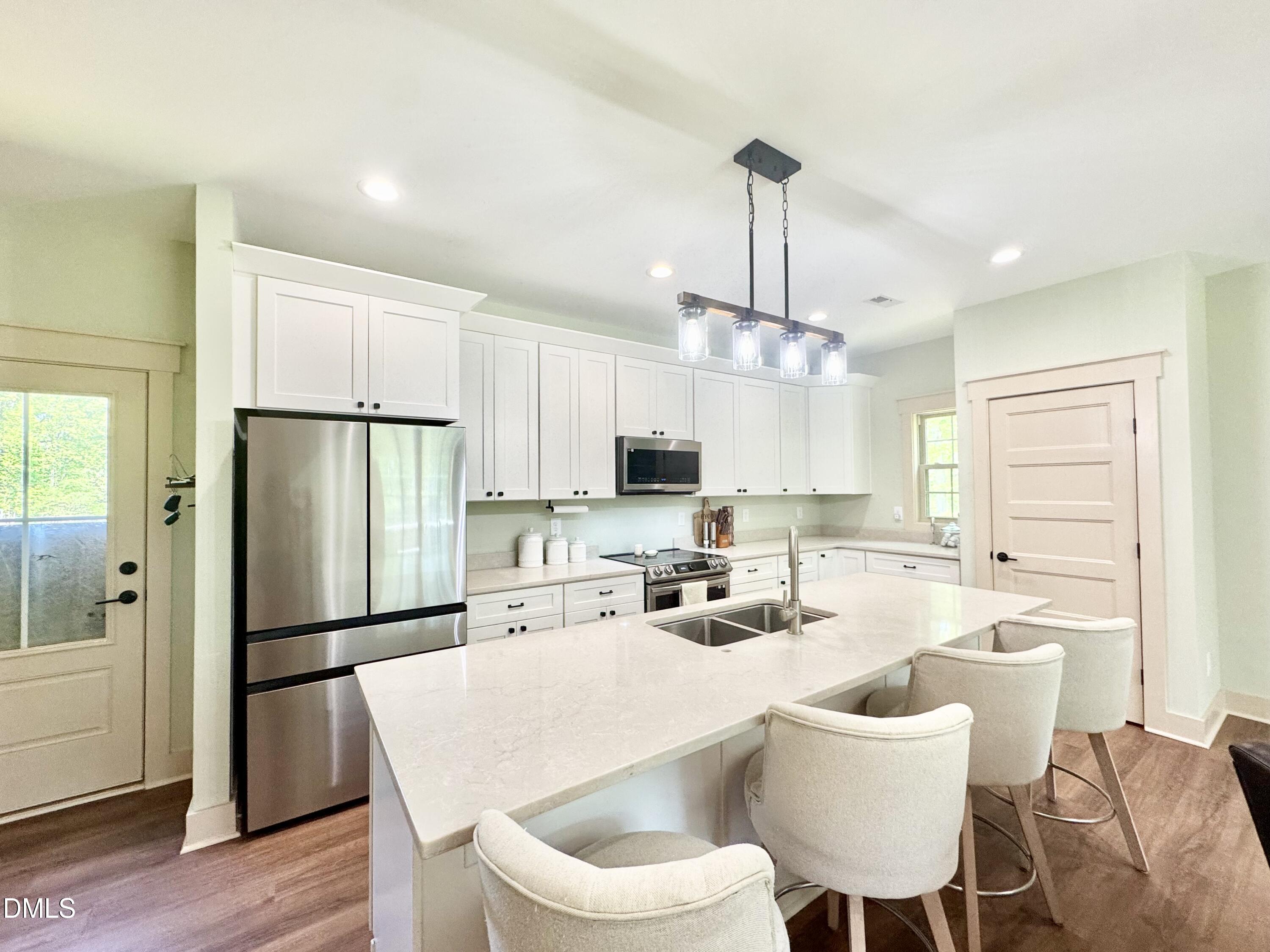 254 Fairway Drive Roxboro, NC 27574 - Photo 3 of 28 a kitchen with stainless steel appliances a dining table chairs refrigerator and sink