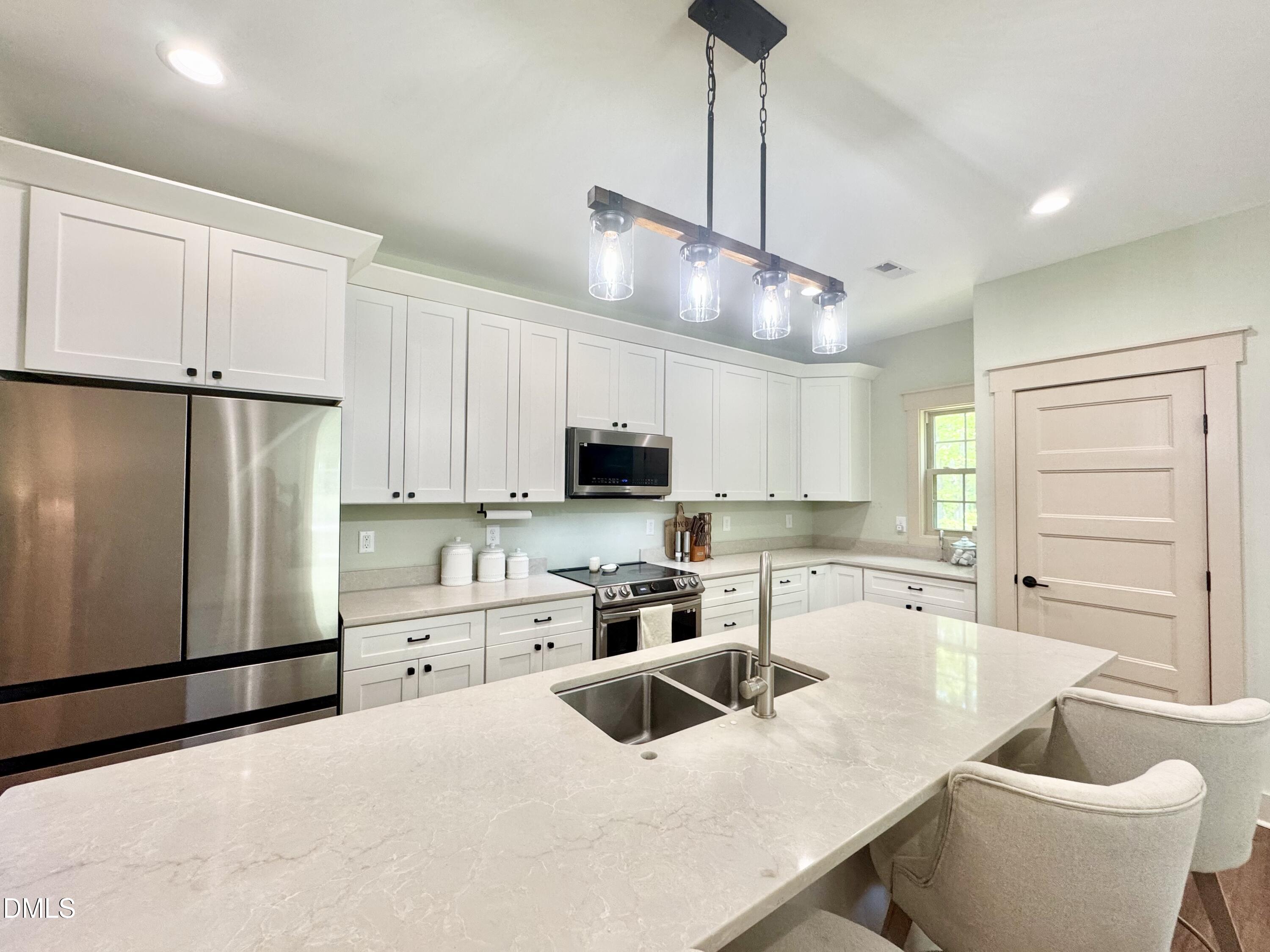 254 Fairway Drive Roxboro, NC 27574 - Photo 4 of 28 a kitchen with stainless steel appliances granite countertop a sink a stove a refrigerator and island with wooden floor