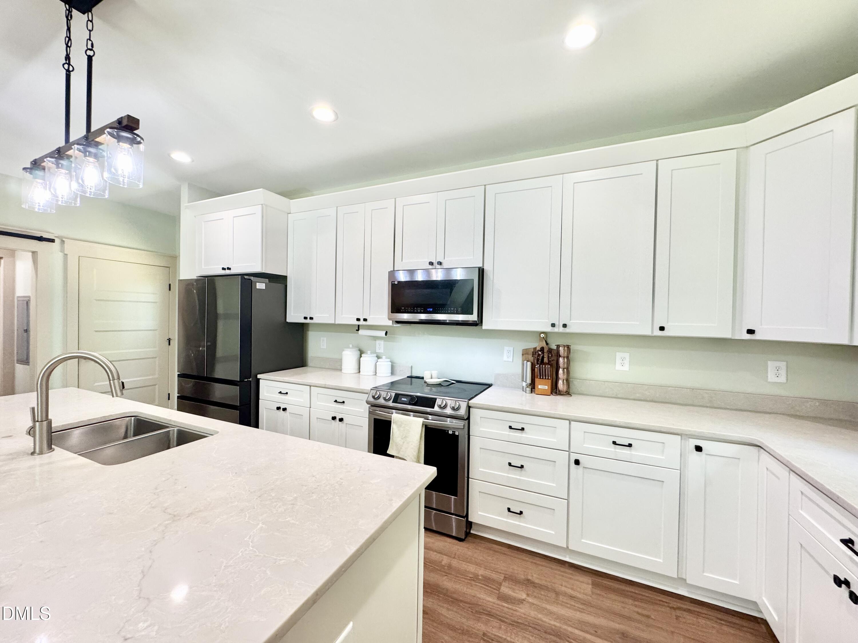 254 Fairway Drive Roxboro, NC 27574 - Photo 5 of 28 a kitchen with white cabinets and stainless steel appliances