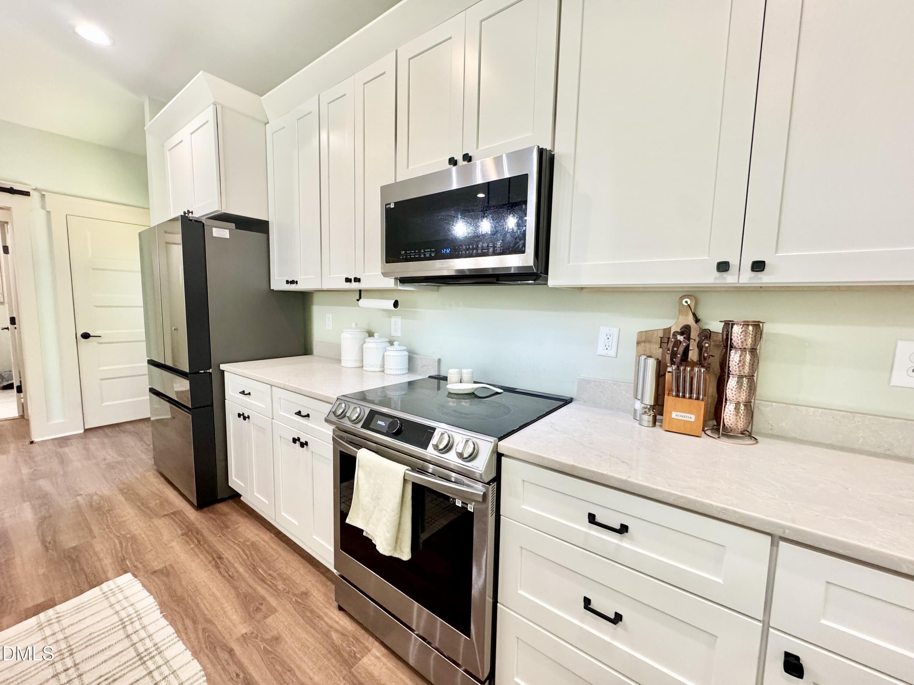 254 Fairway Drive Roxboro, NC 27574 - Photo 6 of 28 a kitchen with stainless steel appliances white cabinets and a stove