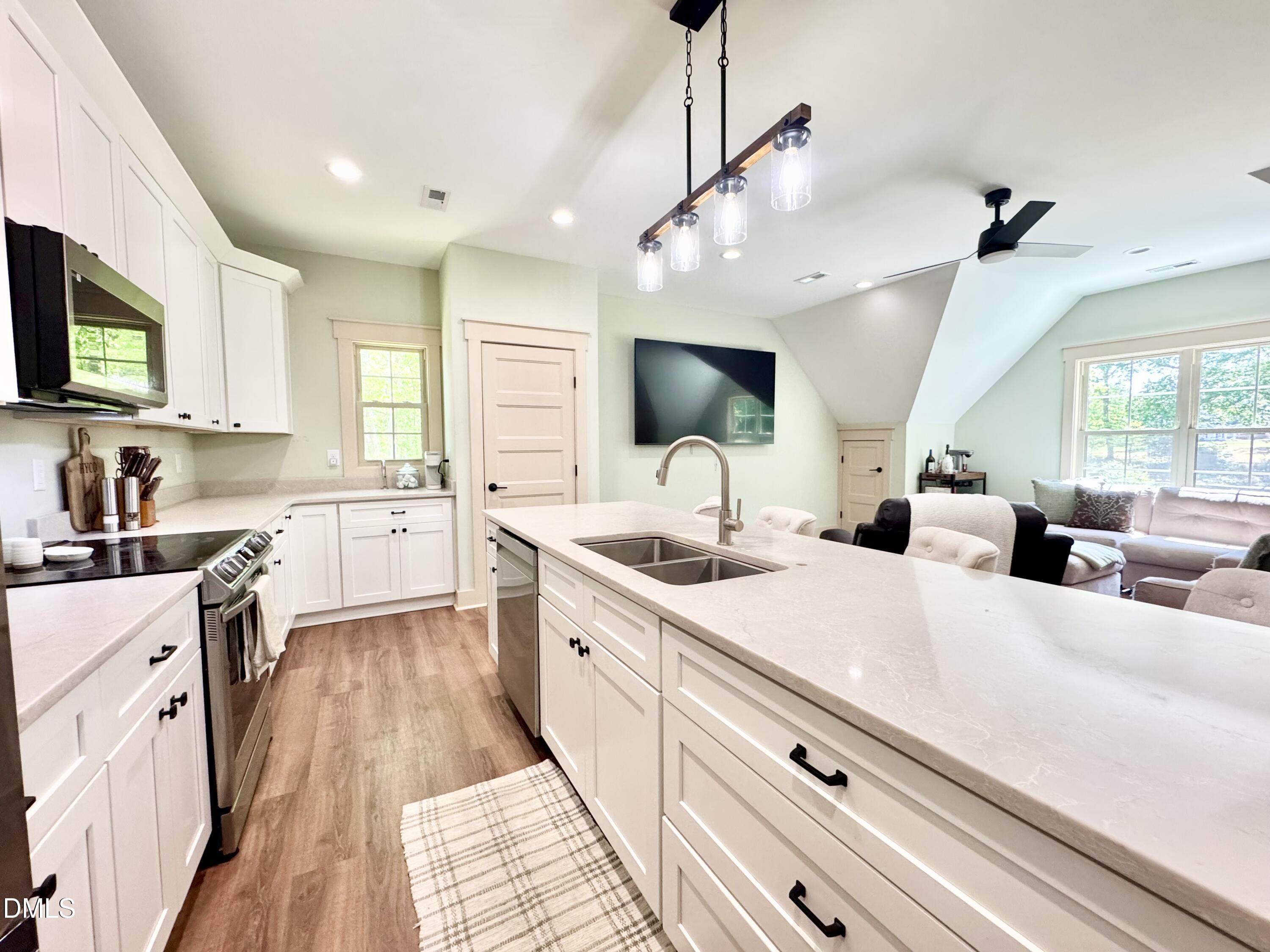 254 Fairway Drive Roxboro, NC 27574 - Photo 7 of 28 a large kitchen with stainless steel appliances kitchen island granite countertop a sink counter space a window and a view of living room