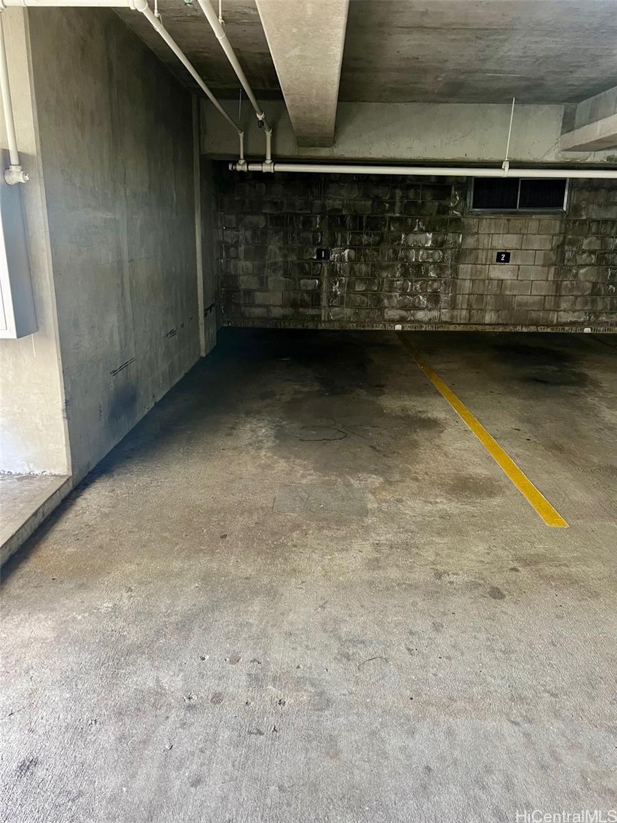 469 Ena Road, Unit 2010 Honolulu, HI 96815 - Photo 17 of 25 Full size covered parking space on second level. Door to dog park on the left of the parking stall