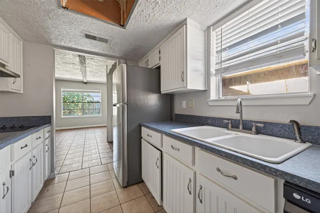 a kitchen with granite countertop a sink stove and cabinets