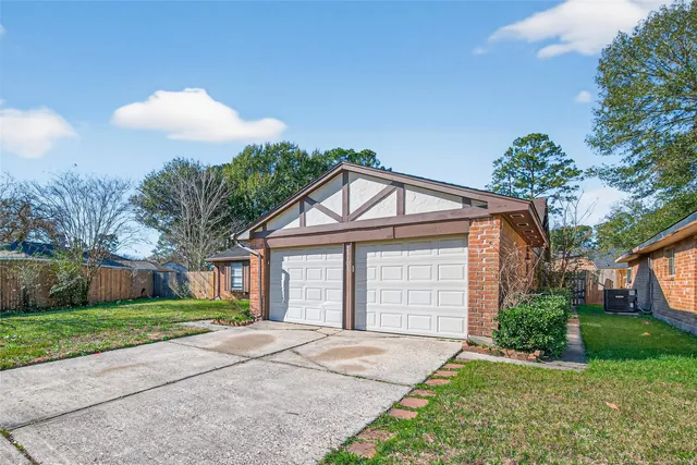 a view of a house with a yard and large tree