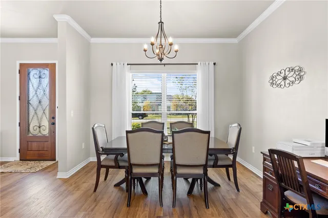 a living room with furniture kitchen view and a chandelier