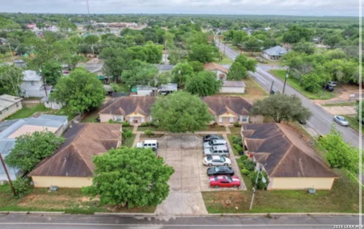 an aerial view of residential houses with outdoor space and trees