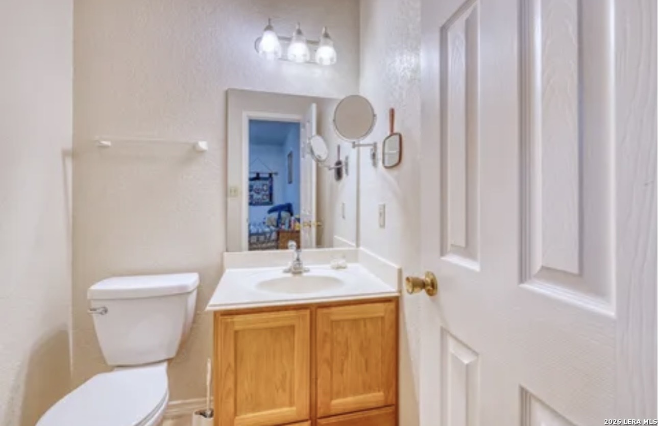 622 South Oak Street Pearsall, TX 78061 - Photo 11 of 22 a bathroom with a sink a toilet and a mirror