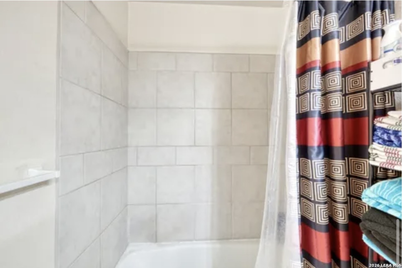 622 South Oak Street Pearsall, TX 78061 - Photo 17 of 22 a bathroom with a bathtub and shower