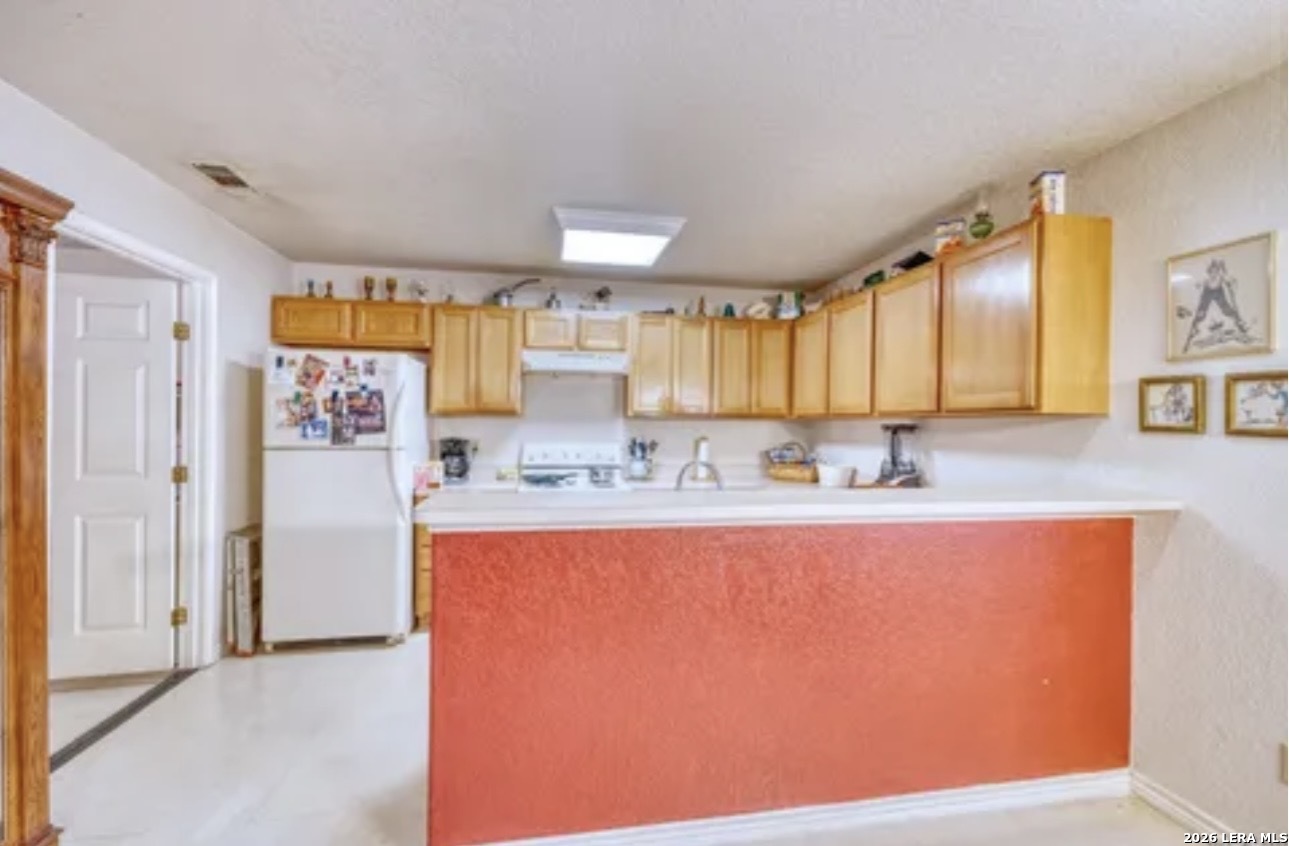 622 South Oak Street Pearsall, TX 78061 - Photo 7 of 22 a large kitchen with stainless steel appliances granite countertop a refrigerator and a stove top oven