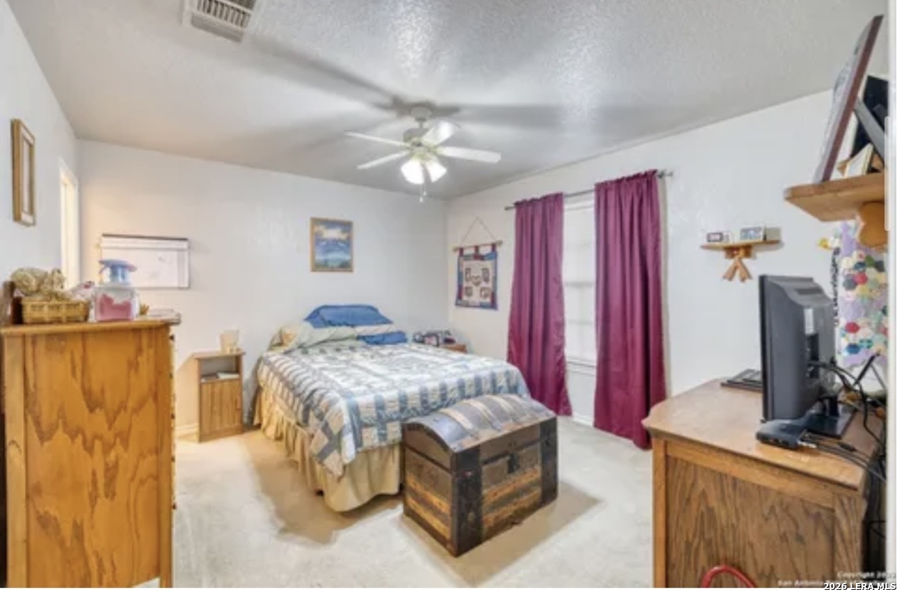 622 South Oak Street Pearsall, TX 78061 - Photo 10 of 22 a bedroom with a bed and a flat tv screen on dresser
