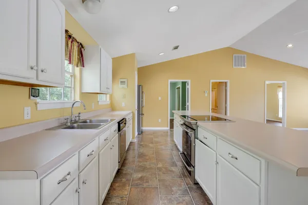 a large kitchen with a sink and cabinets
