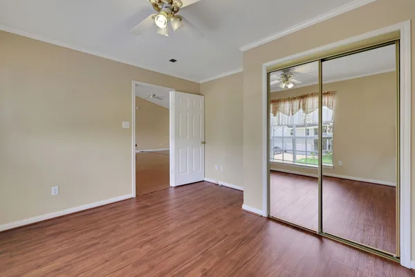 an empty room with wooden floor and windows