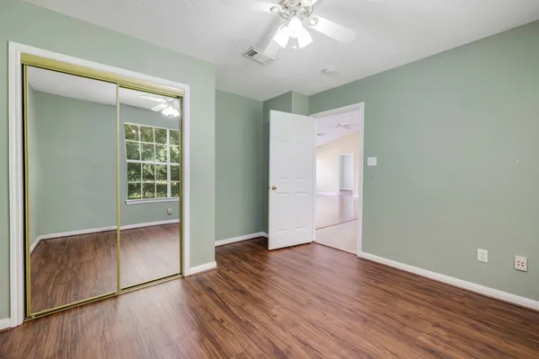 an empty room with wooden floor and windows