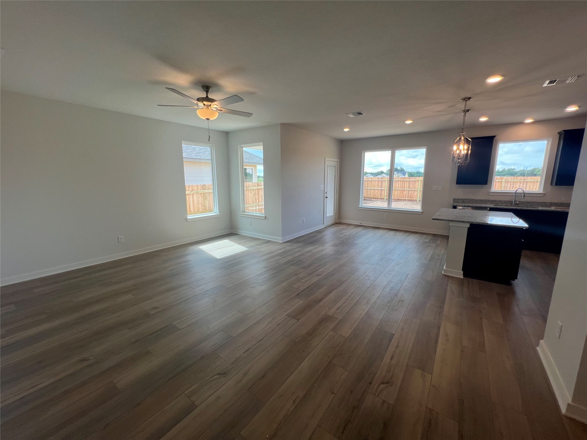 255 Gus Loop Georgetown, TX 78626 - Photo 10 of 24 An open-concept layout unites the living area and kitchen, featuring lustrous hardwood flooring and plentiful natural light.