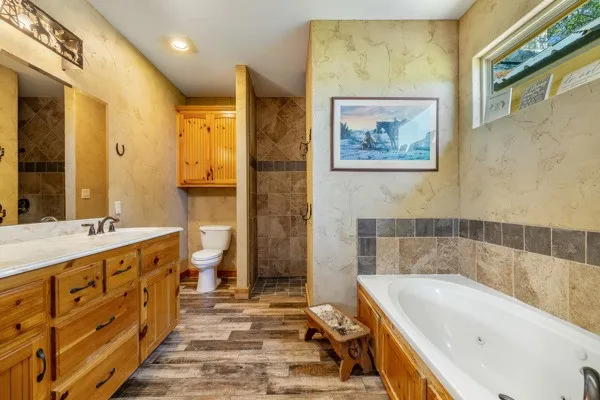 a bathroom with a tub a sink and a large mirror