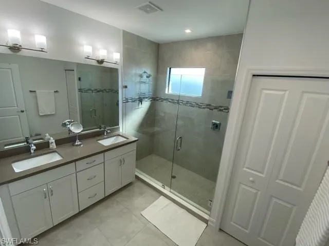 a bathroom with double vanity and a mirror