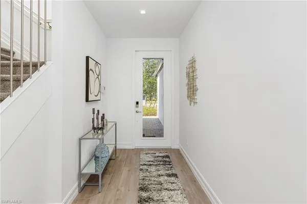 a hallway with a white walls and a window