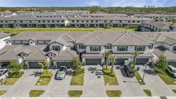 an aerial view of residential houses with outdoor space and ocean view