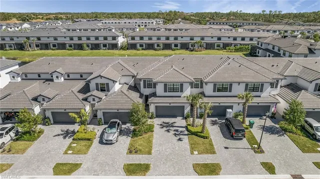 an aerial view of residential houses with outdoor space and ocean view