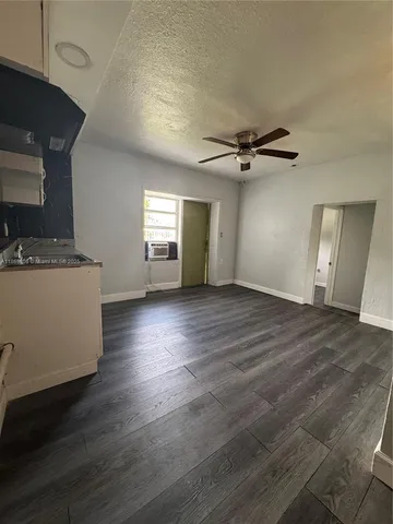 a view of a livingroom with a furniture wooden floor and a ceiling fan