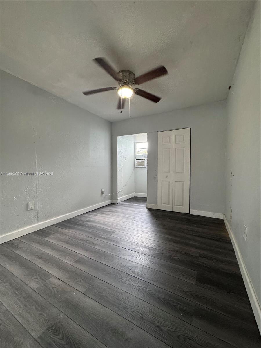 7802 Northwest 8th Avenue, Unit 2 Miami, FL 33150 - Photo 3 of 7 a view of an empty room with wooden floor and a ceiling fan