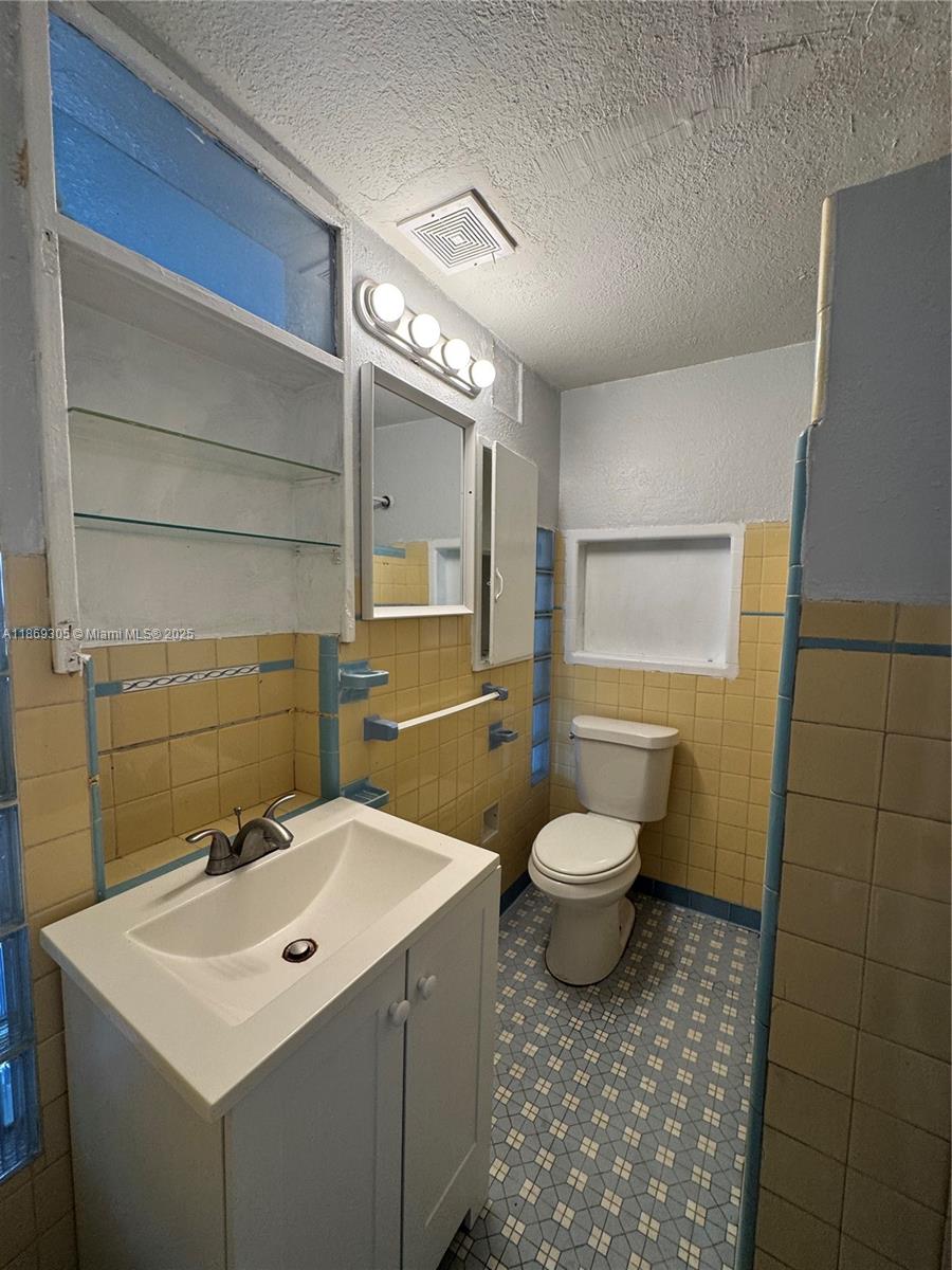 7802 Northwest 8th Avenue, Unit 2 Miami, FL 33150 - Photo 6 of 7 a bathroom with a toilet sink and mirror