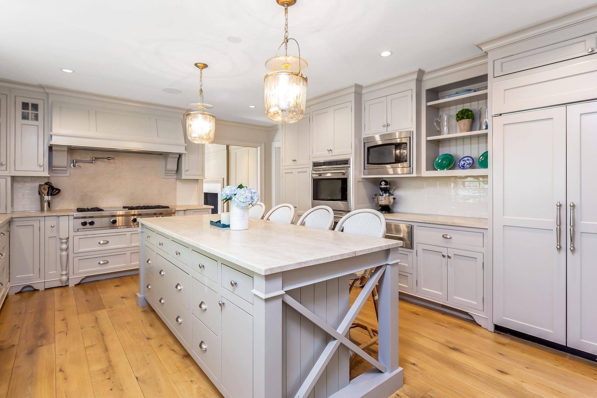 100 Pembroke Road Darien, CT 06820 - Photo 14 of 43 a kitchen with kitchen island granite countertop a stove a sink a refrigerator and white cabinets with wooden floor