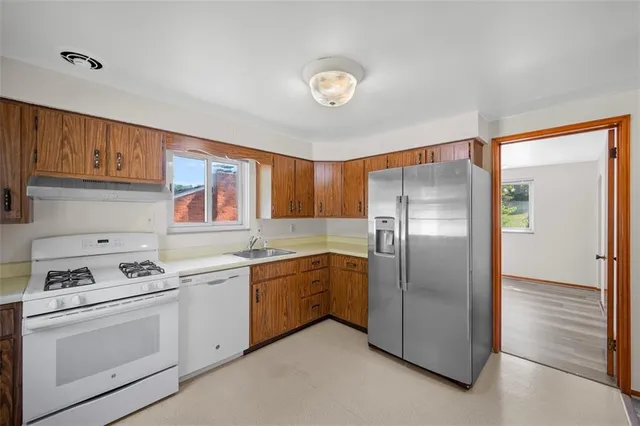 a kitchen with a refrigerator sink and cabinets
