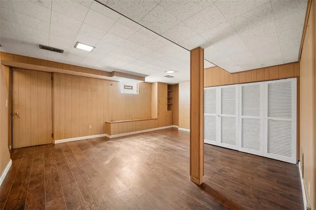 an empty room with wooden floor and window
