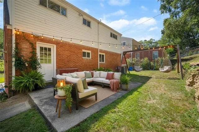 a view of a patio with couches table and chairs with plants and trees