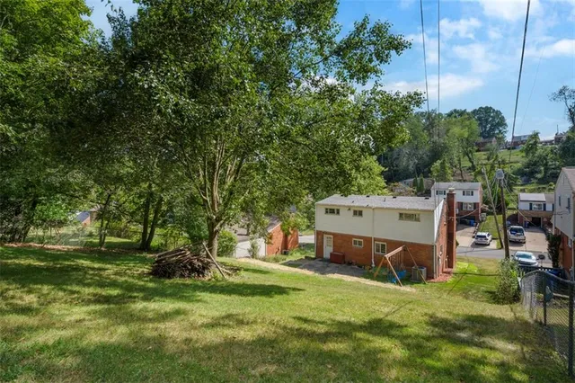 a view of a house with a yard and sitting area